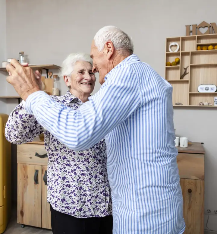 Senior couple hugging at home